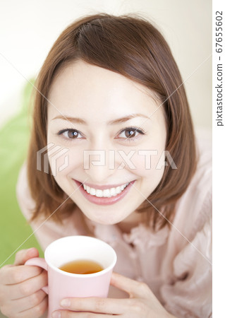 A woman drinking a drink 67655602