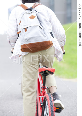 Rear view of a man riding a bicycle Rear view of a man riding a bicycle 67656122