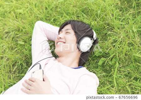 一個男人聽音樂躺在草地上 一個男人聽音樂躺在草地上 67656696