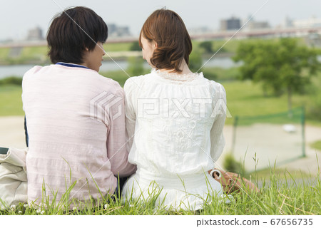 A couple sitting on the riverbed A couple sitting on the riverbed 67656735