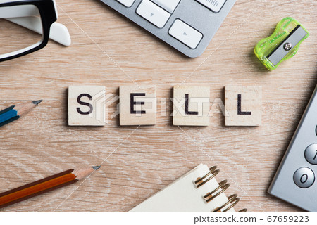 Office stuff and SELL word spelled with wooden blocks on workplace table Office stuff and SELL word spelled with wooden blocks on workplace table 67659223