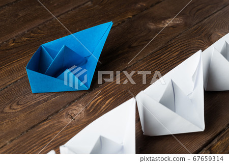 Business leadership concept with white and color paper boats on wooden table 67659314