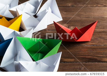 Business leadership concept with white and color paper boats on wooden table 67659315