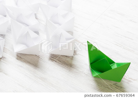 Business leadership concept with white and color paper boats on wooden table 67659364