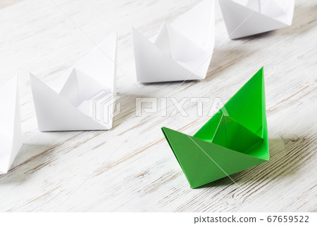 Business leadership concept with white and color paper boats on wooden table 67659522