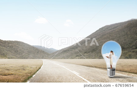Businesswoman inside light bulb Businesswoman inside light bulb 67659654