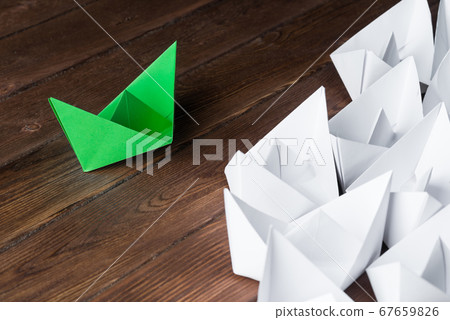 Business leadership concept with white and color paper boats on wooden table 67659826