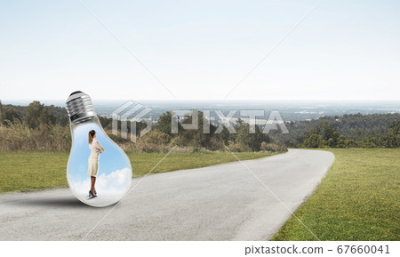 Businesswoman inside light bulb Businesswoman inside light bulb 67660041