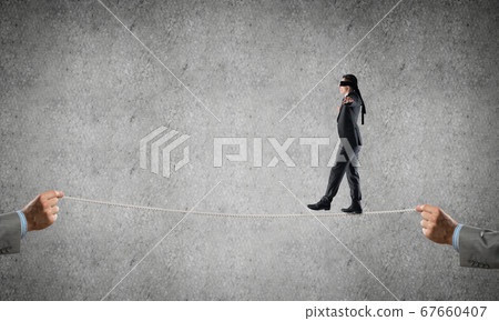 Business concept of risk support and assistance with man balancing on rope Business concept of risk support and assistance with man balancing on rope 67660407