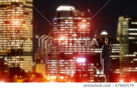 Woman looking at night city 67660574