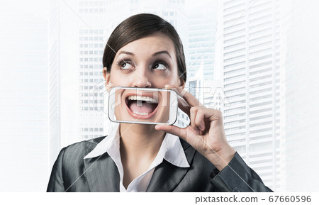 Woman covering her mouth with smartphone 67660596