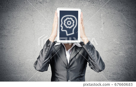 Woman covering her face with tablet computer Woman covering her face with tablet computer 67660683