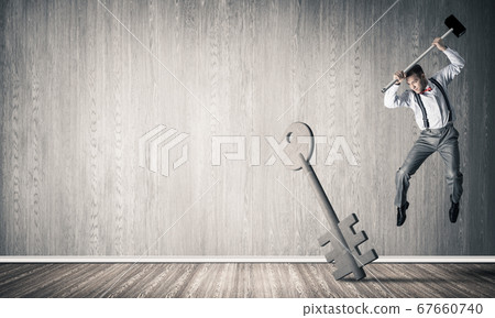 Breaking through access concept with man in room crashing concrete key Breaking through access concept with man in room crashing concrete key 67660740