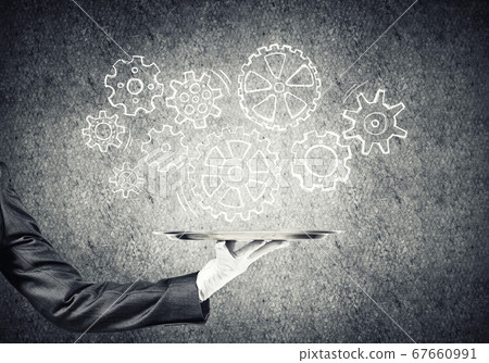 Waiter hand with empty silver tray and drawn gears concept Waiter hand with empty silver tray and drawn gears concept 67660991