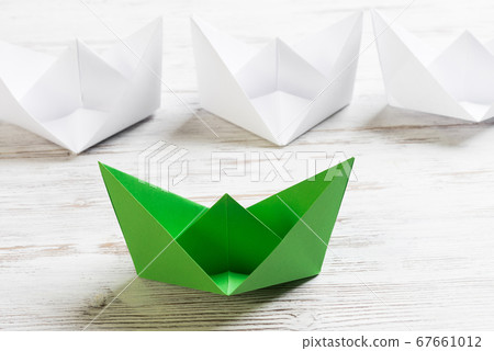 Business leadership concept with white and color paper boats on wooden table 67661012