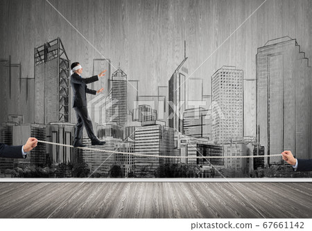 Business concept of risk support and assistance with man balancing on rope 67661142