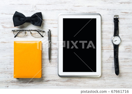 Gentleman kit of tablet watch glasses bow tie and notebook on wooden table Gentleman kit of tablet watch glasses bow tie and notebook on wooden table 67661716