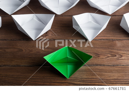 Business leadership concept with white and color paper boats on wooden table 67661781