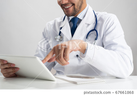 Happy young doctor using tablet computer Happy young doctor using tablet computer 67661868