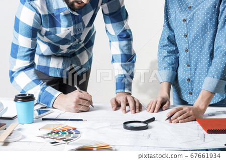 Man writing with pen on technical drawing Man writing with pen on technical drawing 67661934