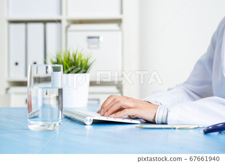 Doctor typing at computer keyboard Doctor typing at computer keyboard 67661940