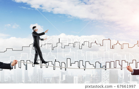 Business concept of risk support and assistance with man balancing on rope Business concept of risk support and assistance with man balancing on rope 67661997