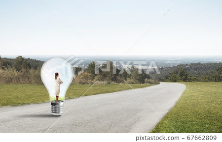 Businesswoman inside light bulb Businesswoman inside light bulb 67662809