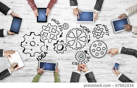 Top view of businesspeople sitting at table and using gadgets Top view of businesspeople sitting at table and using gadgets 67662838