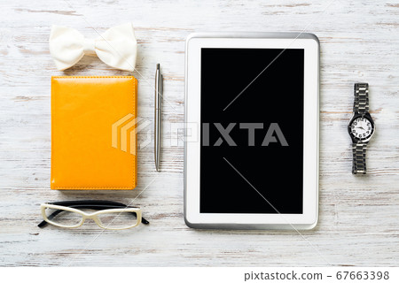 Gentleman kit of tablet watch glasses bow tie and notebook on wooden table Gentleman kit of tablet watch glasses bow tie and notebook on wooden table 67663398