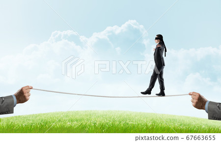 Business concept of risk support and assistance with man balancing on rope 67663655