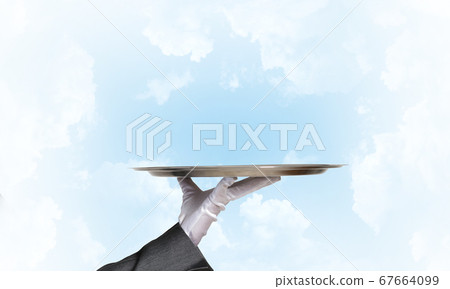 Waiter holding empty silver platter ready for product or item placement Waiter holding empty silver platter ready for product or item placement 67664099