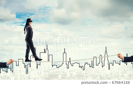 Business concept of risk support and assistance with man balancing on rope Business concept of risk support and assistance with man balancing on rope 67664188