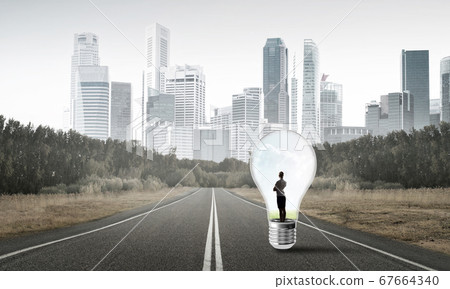 Businesswoman inside light bulb Businesswoman inside light bulb 67664340