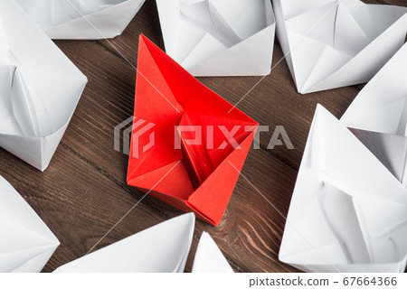 Business leadership concept with white and color paper boats on wooden table 67664366