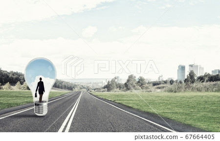 Businesswoman inside light bulb Businesswoman inside light bulb 67664405