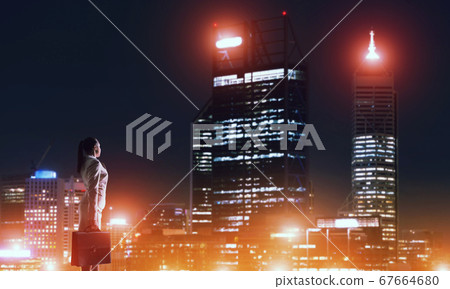 Woman looking at night city 67664680