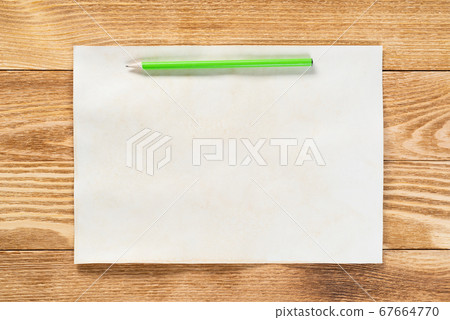 Sheet of paper lying on wooden table Sheet of paper lying on wooden table 67664770