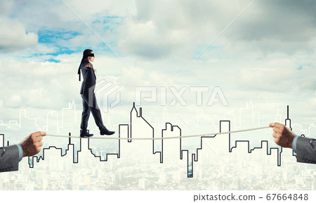 Business concept of risk support and assistance with man balancing on rope 67664848