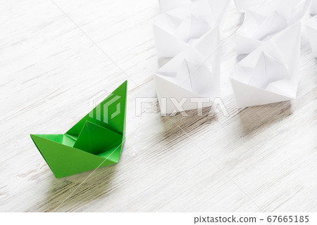 Business leadership concept with white and color paper boats on wooden table 67665185