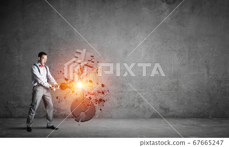 Breaking through access concept with man in room crashing concrete key Breaking through access concept with man in room crashing concrete key 67665247