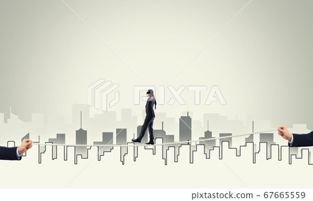 Business concept of risk support and assistance with man balancing on rope 67665559