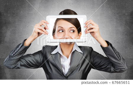 Woman covering her face with tablet computer 67665651