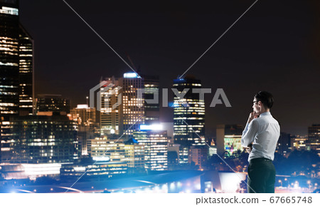 Businessman viewing night glowing city 67665748