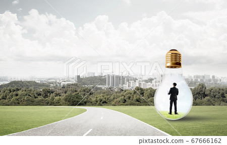 Businessman inside light bulb 67666162