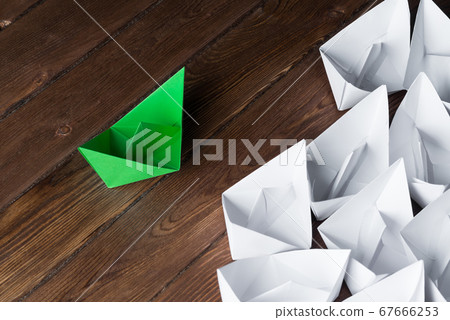 Business leadership concept with white and color paper boats on wooden table 67666253