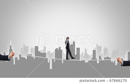 Business concept of risk support and assistance with man balancing on rope 67666270