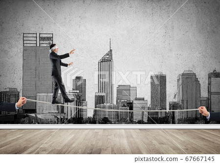 Business concept of risk support and assistance with man balancing on rope 67667145