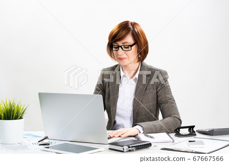 Attractive middle aged businesswoman working Attractive middle aged businesswoman working 67667566
