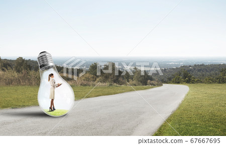 Businesswoman inside light bulb Businesswoman inside light bulb 67667695