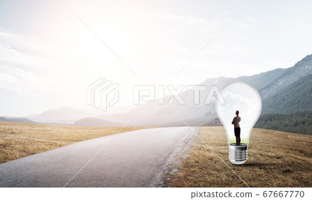 Businesswoman inside light bulb Businesswoman inside light bulb 67667770